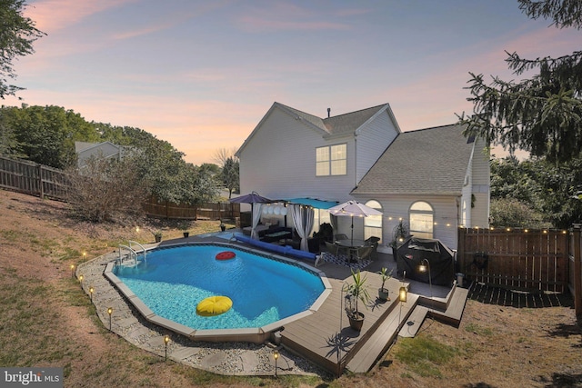 view of swimming pool featuring a wooden deck and a fenced backyard