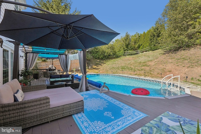 outdoor pool with a deck and outdoor lounge area
