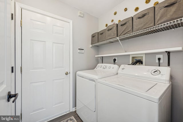 clothes washing area with separate washer and dryer and dark wood-type flooring
