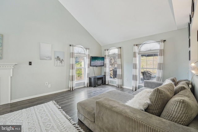 living room with high vaulted ceiling, baseboards, and wood finished floors