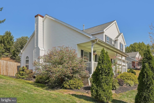 view of home's exterior featuring covered porch and a chimney
