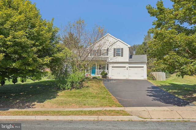 traditional home featuring asphalt driveway and a garage