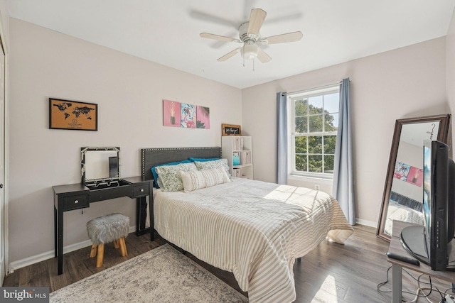 bedroom with wood finished floors, baseboards, and a ceiling fan
