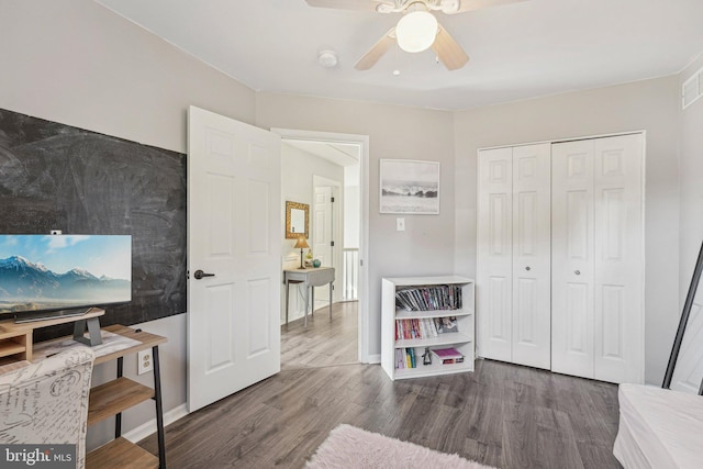 bedroom with wood finished floors, a closet, baseboards, and ceiling fan