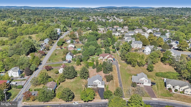 aerial view of property and surrounding area with nearby suburban area and a forest