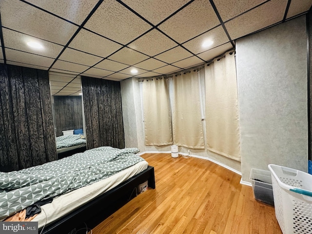 bedroom featuring recessed lighting, wood finished floors, and a paneled ceiling