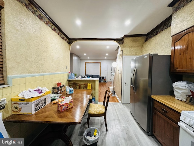 kitchen featuring white range oven, light wood-style floors, crown molding, stainless steel refrigerator with ice dispenser, and recessed lighting