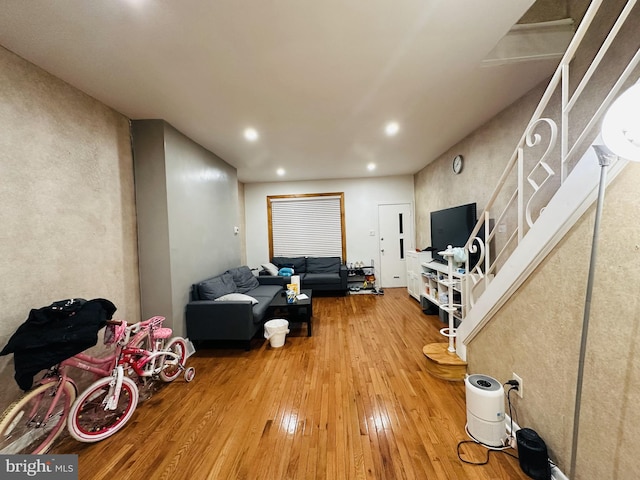 living room featuring hardwood / wood-style flooring, recessed lighting, and stairway