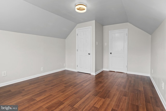 bonus room featuring lofted ceiling, dark wood-style floors, and baseboards