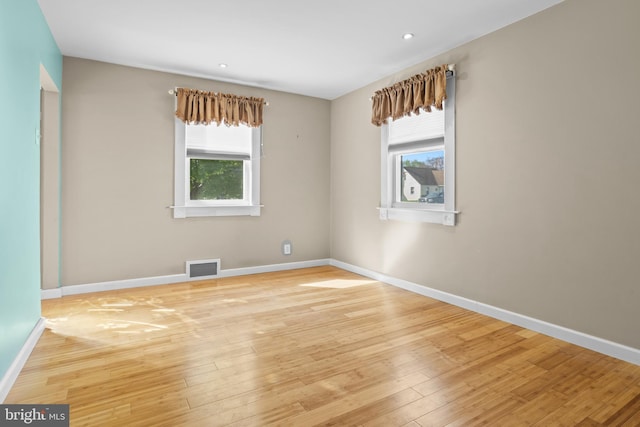 unfurnished room featuring healthy amount of natural light, baseboards, hardwood / wood-style floors, and recessed lighting
