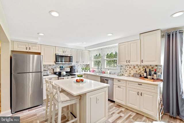5 Neptune Ln, Willingboro, NJ 08046 - kitchen featuring stainless steel appliances, decorative backsplash, light countertops, a sink, and light wood finished floors