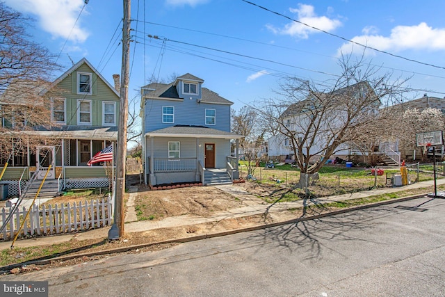 2305 James St, Baltimore, MD 21230 - traditional style home with a porch, a fenced front yard, and roof with shingles