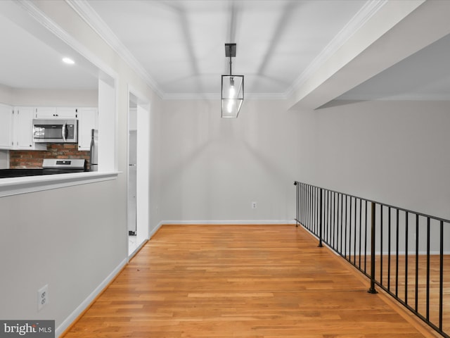 hallway featuring light wood-type flooring, crown molding, baseboards, and recessed lighting