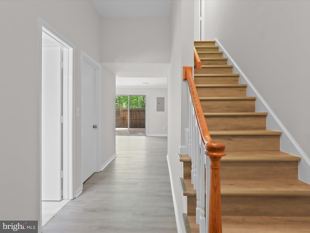 stairs with wood finished floors and baseboards
