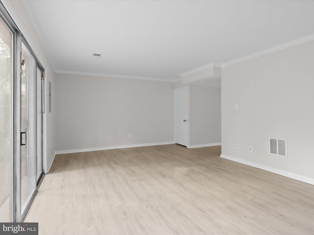 spare room featuring light wood-style flooring, crown molding, and baseboards