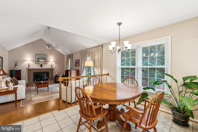 1276 Mason Mill Ct, Herndon, VA 20170 - dining space with vaulted ceiling, light tile patterned floors, a fireplace, a chandelier, and a ceiling fan
