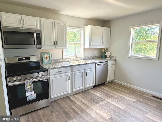20 Flying Dove Ln, Hedgesville, WV 25427 - kitchen featuring stainless steel appliances, a sink, white cabinets, baseboards, and light stone countertops