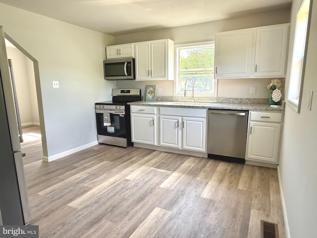 20 Flying Dove Ln, Hedgesville, WV 25427 - kitchen with stainless steel appliances, a sink, light wood finished floors, and white cabinetry