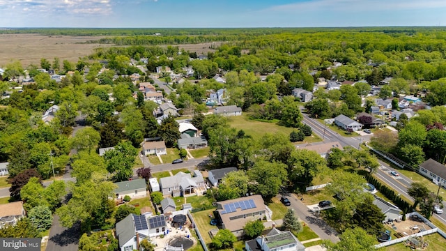 aerial view of property and surrounding area with nearby suburban area and a forest