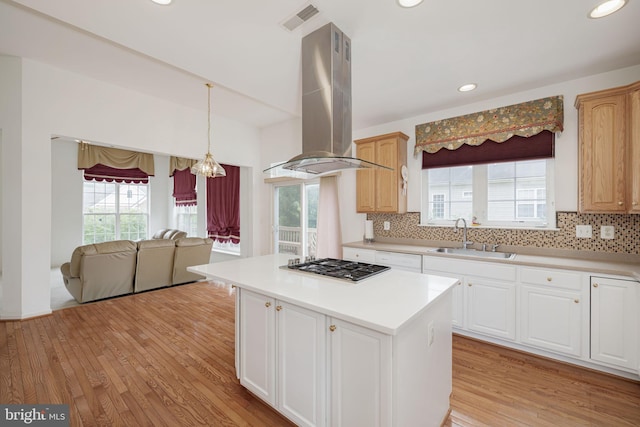 kitchen featuring island range hood, a sink, light wood-type flooring, backsplash, and recessed lighting