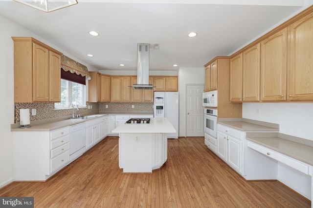 kitchen featuring white appliances, a sink, a center island, light wood-style floors, and decorative backsplash
