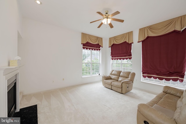 living area featuring a ceiling fan, carpet, a glass covered fireplace, and recessed lighting