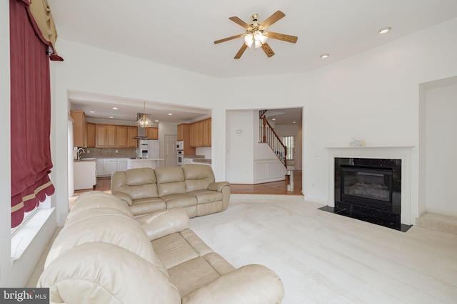living area with a ceiling fan, stairs, recessed lighting, and a fireplace