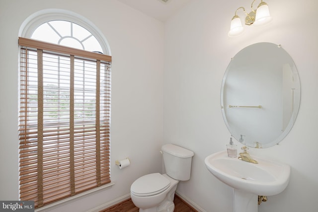 bathroom featuring a sink, toilet, wood finished floors, and baseboards