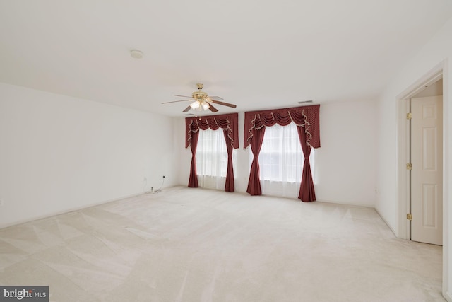 empty room featuring a ceiling fan, carpet flooring, and a smoke detector