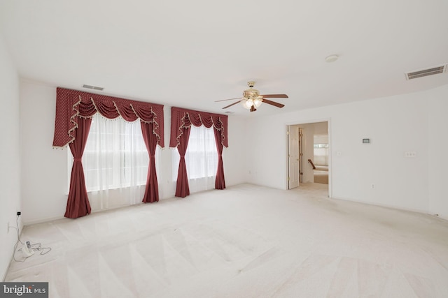 empty room featuring a ceiling fan and carpet floors