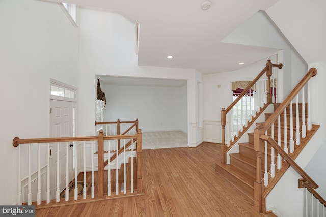 stairway featuring wood finished floors and recessed lighting