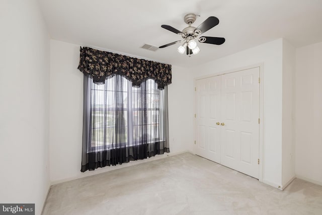 unfurnished bedroom with a closet, carpet flooring, ceiling fan, and baseboards