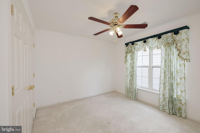spare room featuring carpet floors, ceiling fan, and baseboards