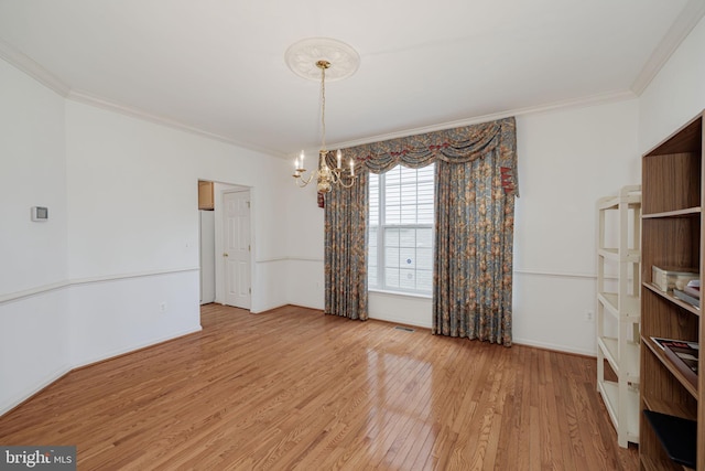 unfurnished dining area featuring ornamental molding, a chandelier, and light wood-style flooring