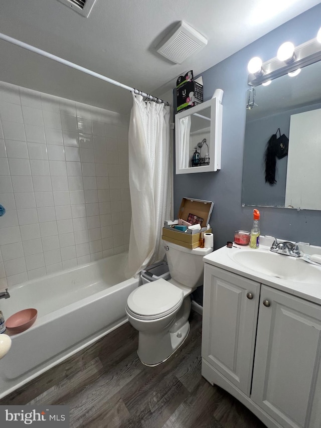 full bathroom featuring wood finished floors, toilet, shower / tub combo with curtain, and vanity