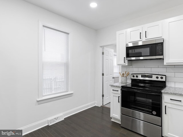 502 N Harrison St, Wilmington, DE 19805 - kitchen featuring appliances with stainless steel finishes, dark wood-style flooring, tasteful backsplash, white cabinets, and light stone countertops