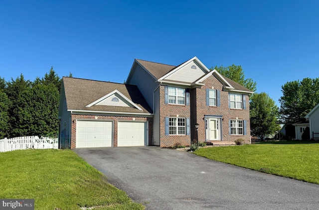 colonial home with a garage, driveway, and brick siding