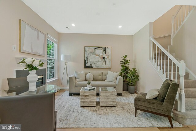 living area with stairway, baseboards, wood finished floors, and recessed lighting