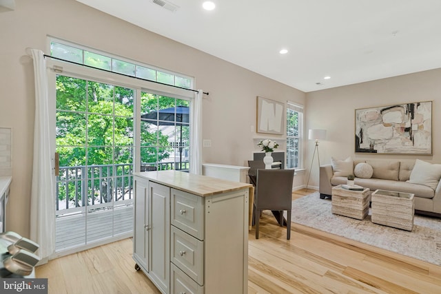 kitchen featuring light wood-type flooring, open floor plan, recessed lighting, butcher block counters, and a kitchen island