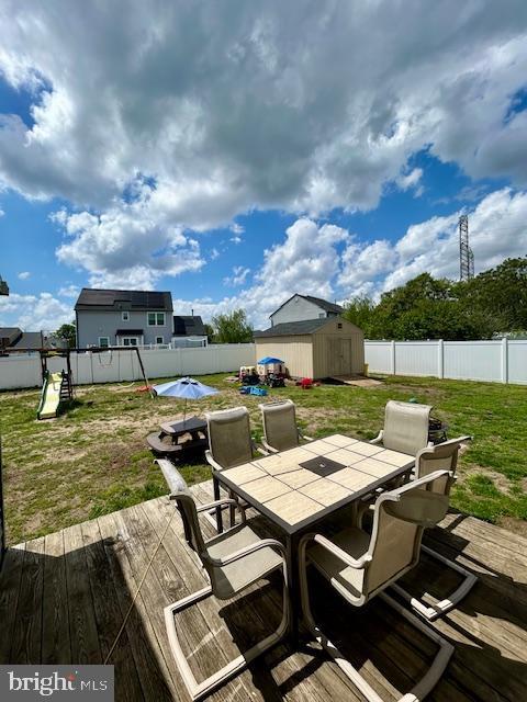 2513 Oakley Pl, Pennsauken, NJ 08109 - view of patio featuring outdoor dining space, a storage unit, a wooden deck, and an outbuilding