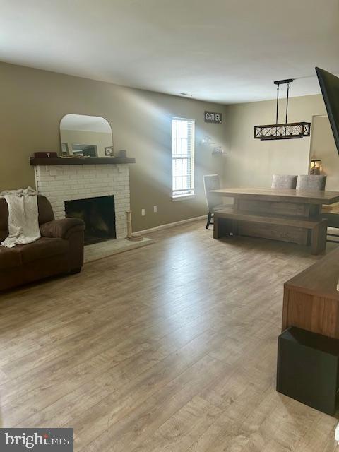 2513 Oakley Pl, Pennsauken, NJ 08109 - living room featuring light wood finished floors, a brick fireplace, and baseboards