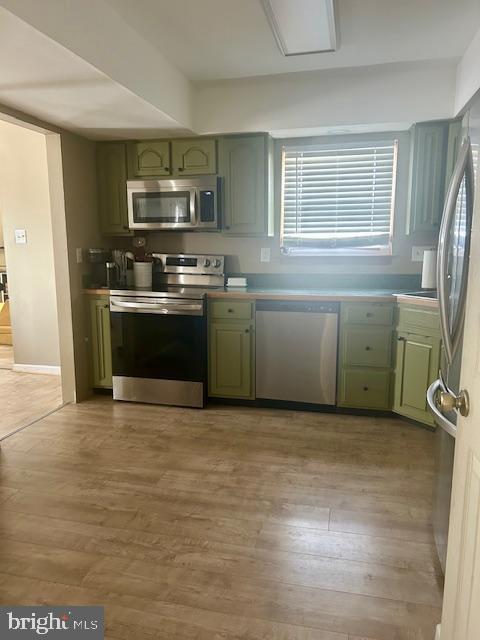 2513 Oakley Pl, Pennsauken, NJ 08109 - kitchen featuring green cabinets, appliances with stainless steel finishes, and light wood-style floors
