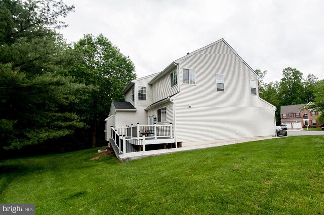 rear view of house featuring a yard and a wooden deck