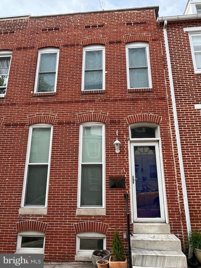 townhome / multi-family property featuring entry steps and brick siding
