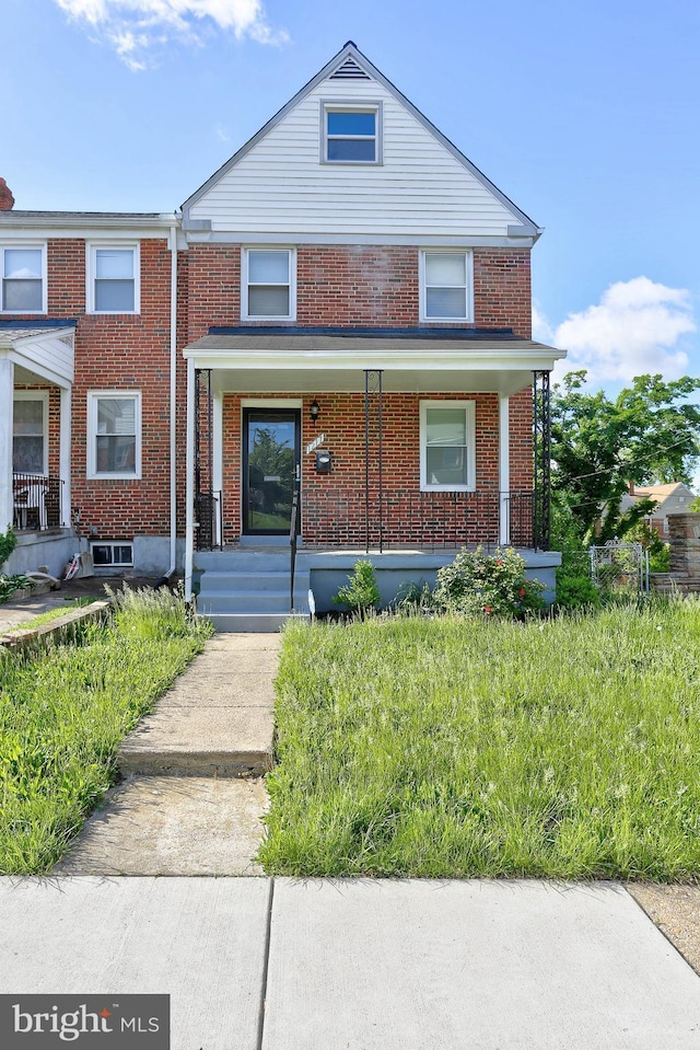 view of front facade featuring covered porch and brick siding