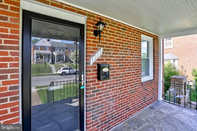 entrance to property with brick siding and covered porch