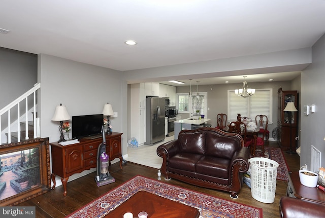 living room featuring wood finished floors, a chandelier, stairs, and recessed lighting