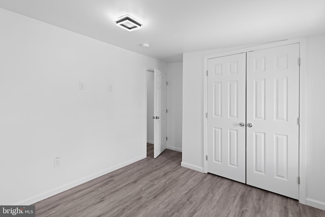 2118 Wilkens Ave, Baltimore, MD 21223 - unfurnished bedroom featuring wood finished floors, a closet, and baseboards
