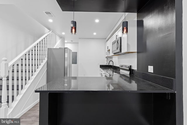 2118 Wilkens Ave, Baltimore, MD 21223 - kitchen with stainless steel appliances, dark stone counters, a peninsula, recessed lighting, and wood finished floors