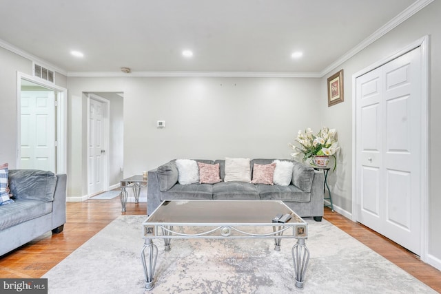 living area with wood finished floors, crown molding, recessed lighting, and baseboards